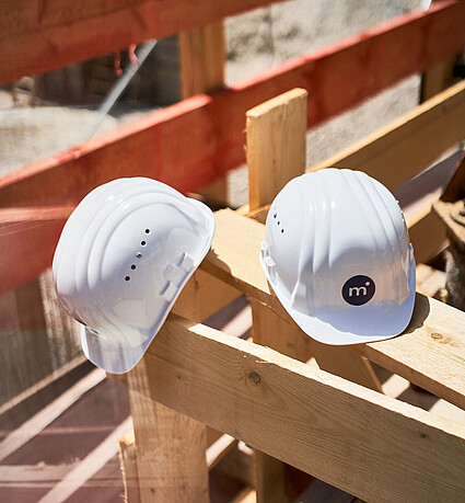 Schutzhelme bei einer Baustelle von Monvest Immobilien GmbH