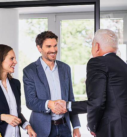 Monvest – Begrüßung des Kundenpaares Handschlag zur Begrüßung eines Kundenpaares bei Monvest Immobilien